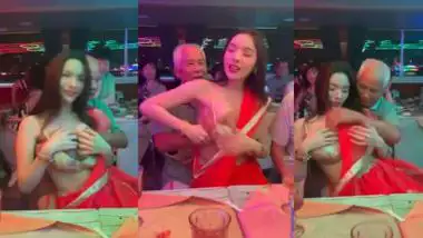 An old man squeezes a whore?s boobs at a public gathering